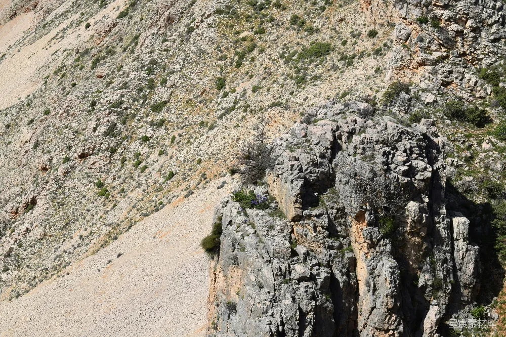 高清摄影  一座岩石山的景色，一只鸟飞在上方。