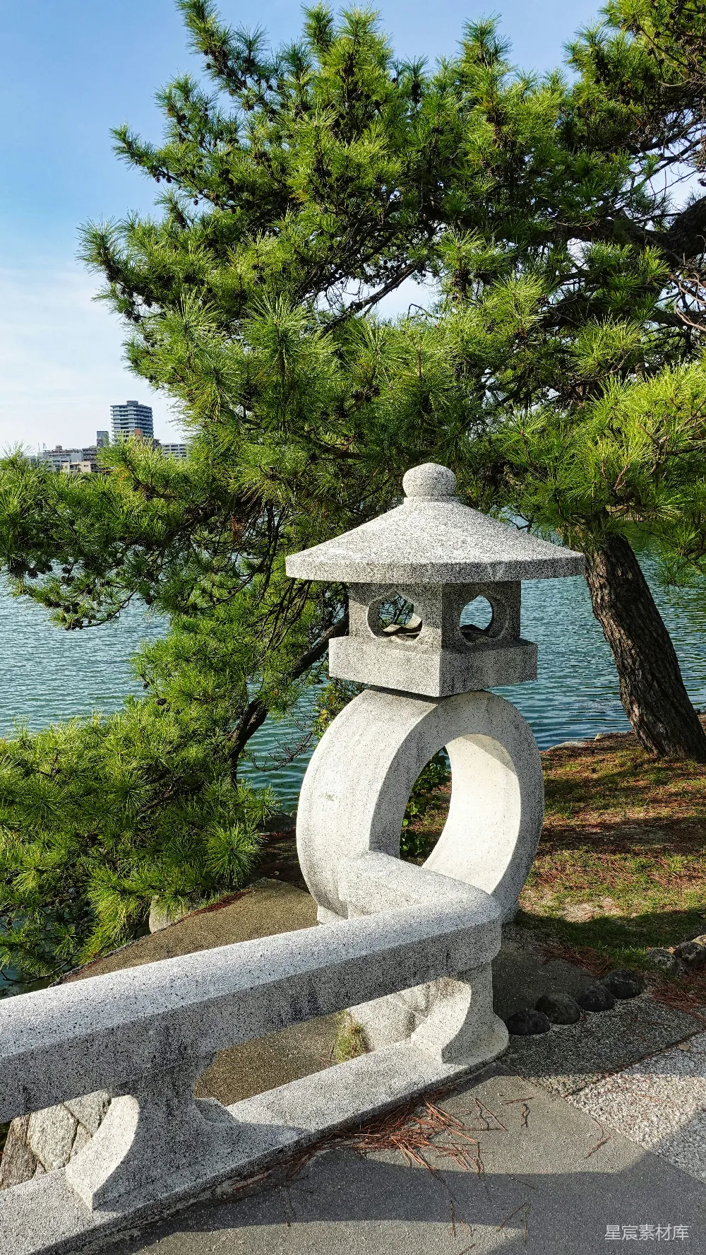 高清摄影  一个石灯笼放在水泥长椅上。
