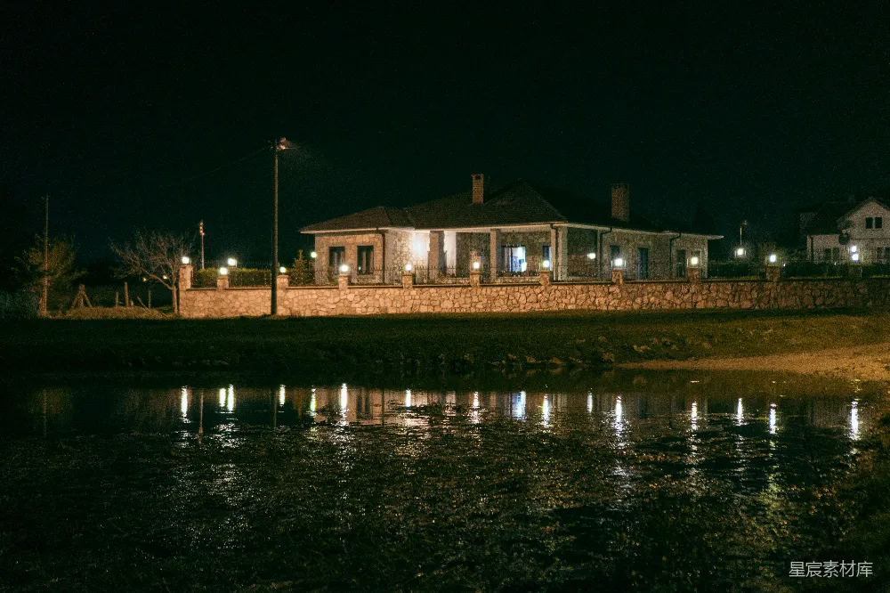 高清摄影  夜晚，一盏亮着的灯在黑暗的水中倒映。