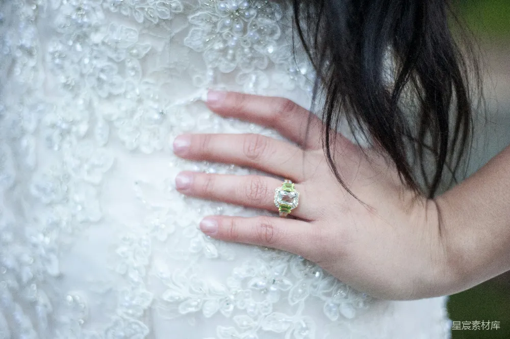 高清摄影  新娘的手在婚纱上戴着订婚戒指