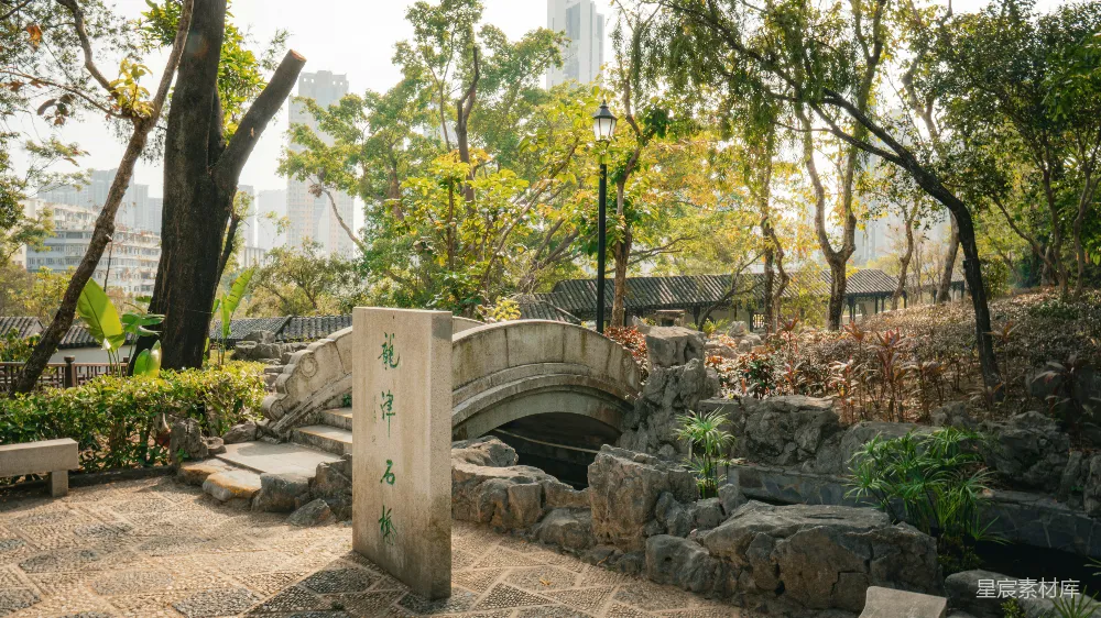 高清摄影  石桥和石碑位于郁郁葱葱的城市公园中。