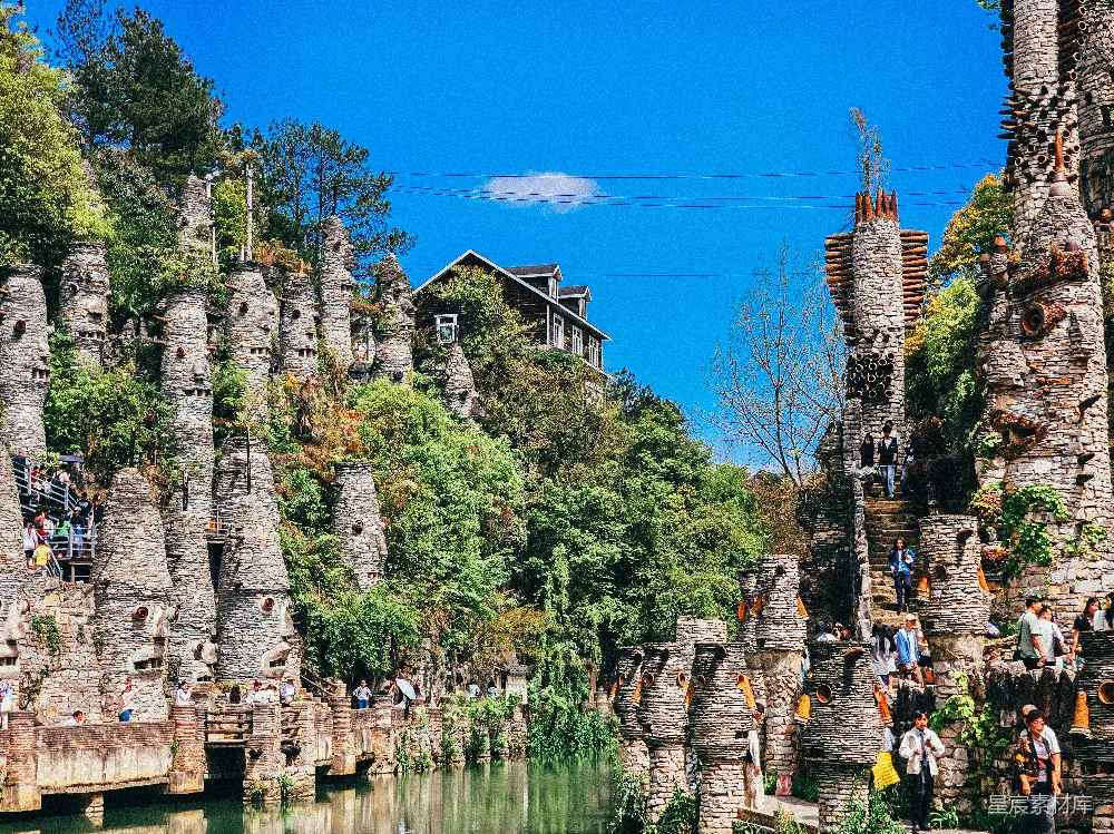 高清摄影  古老的石塔和郁郁葱葱的绿植沿着一条宁静的河流排列。