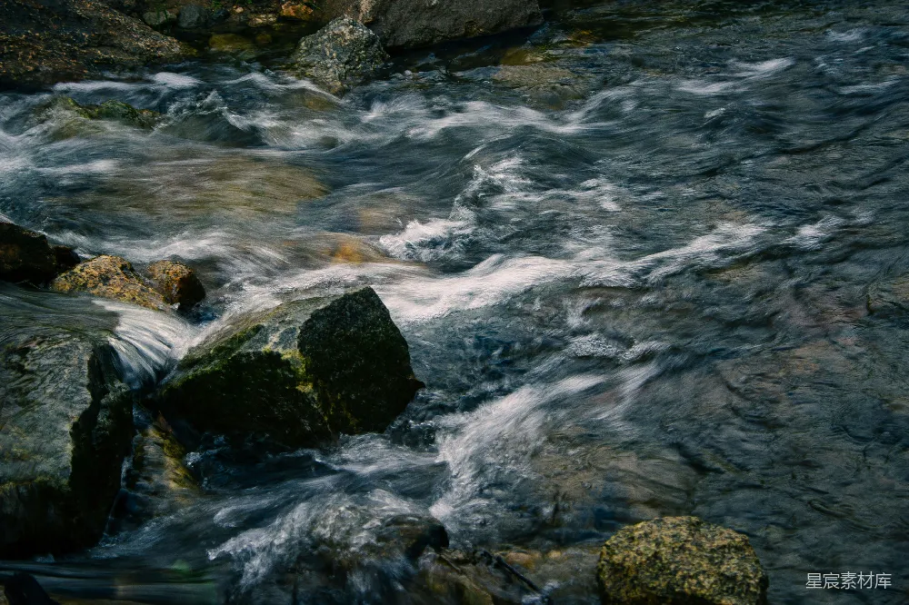 高清摄影  一条河流，河中有岩石，水流潺潺。