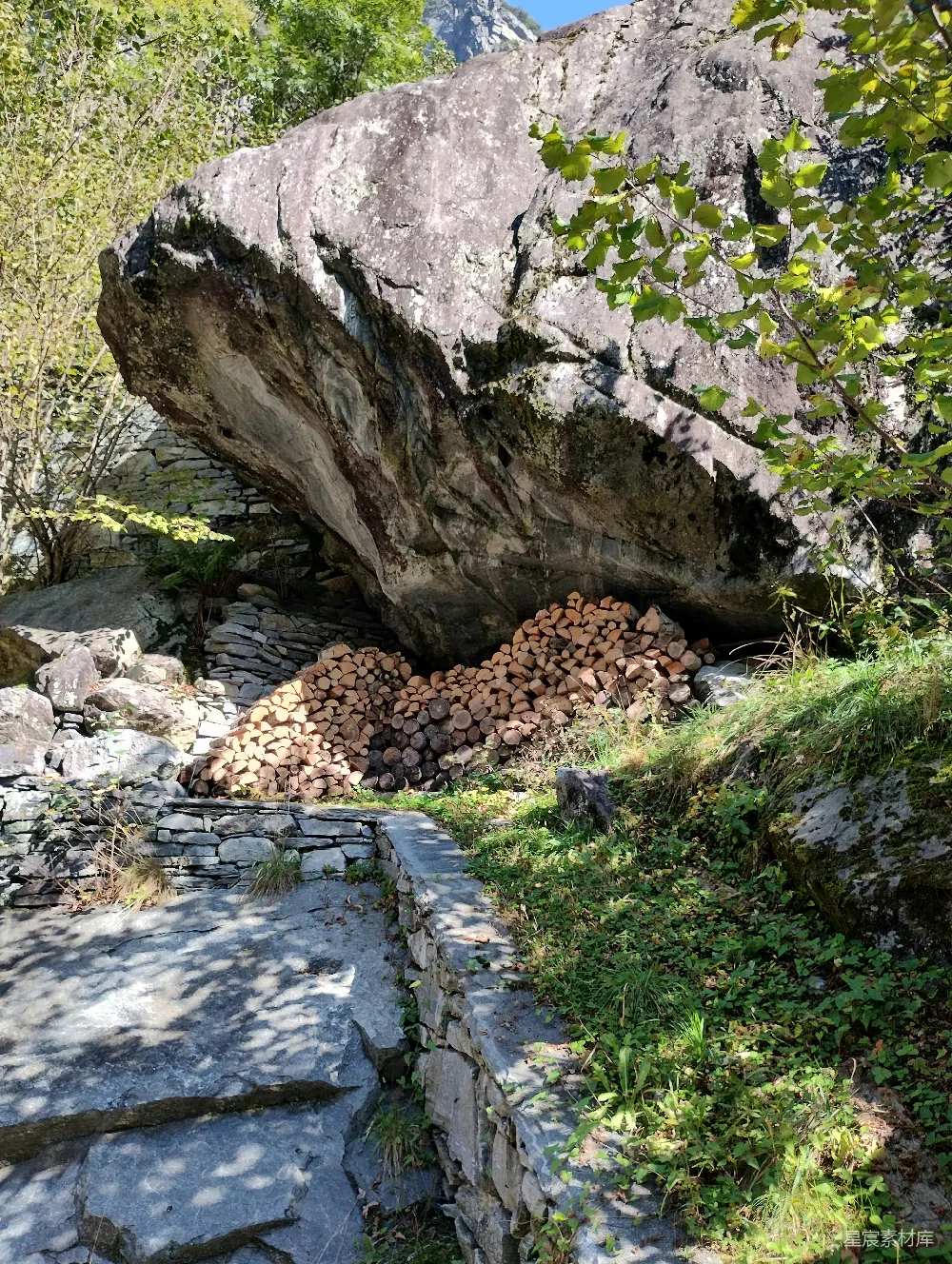 高清摄影  一座巨大的岩石坐落在郁郁葱葱的山坡上。