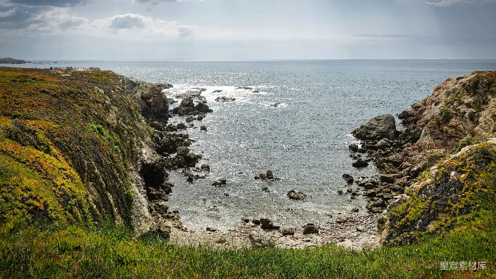 高清摄影  一个岩石海滩，海浪拍打着岩石。