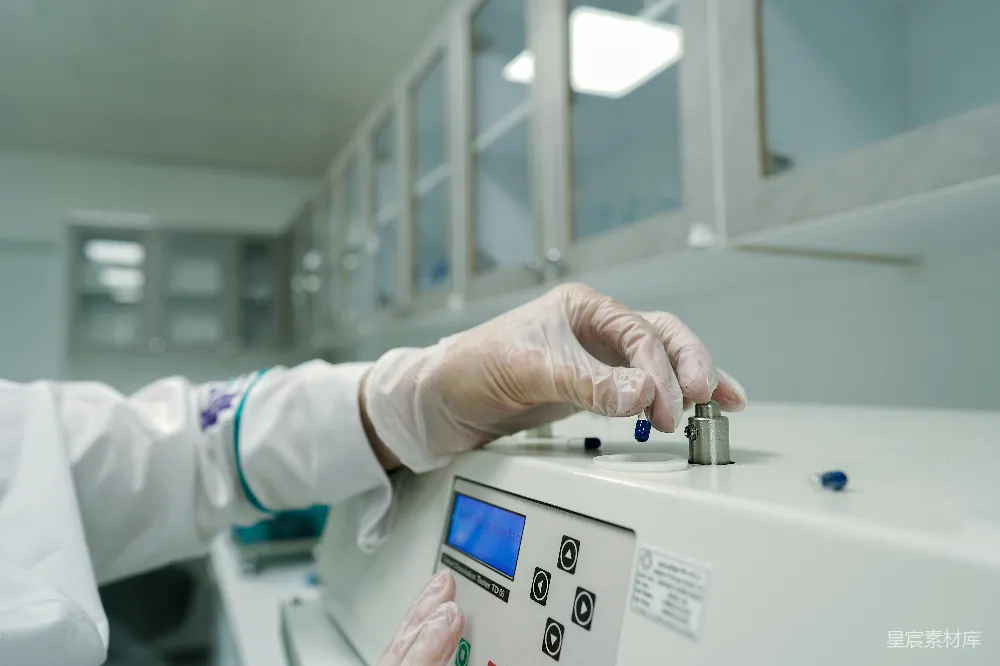 高清摄影  一个穿着实验室外套和戴着手套的人正在操作机器。