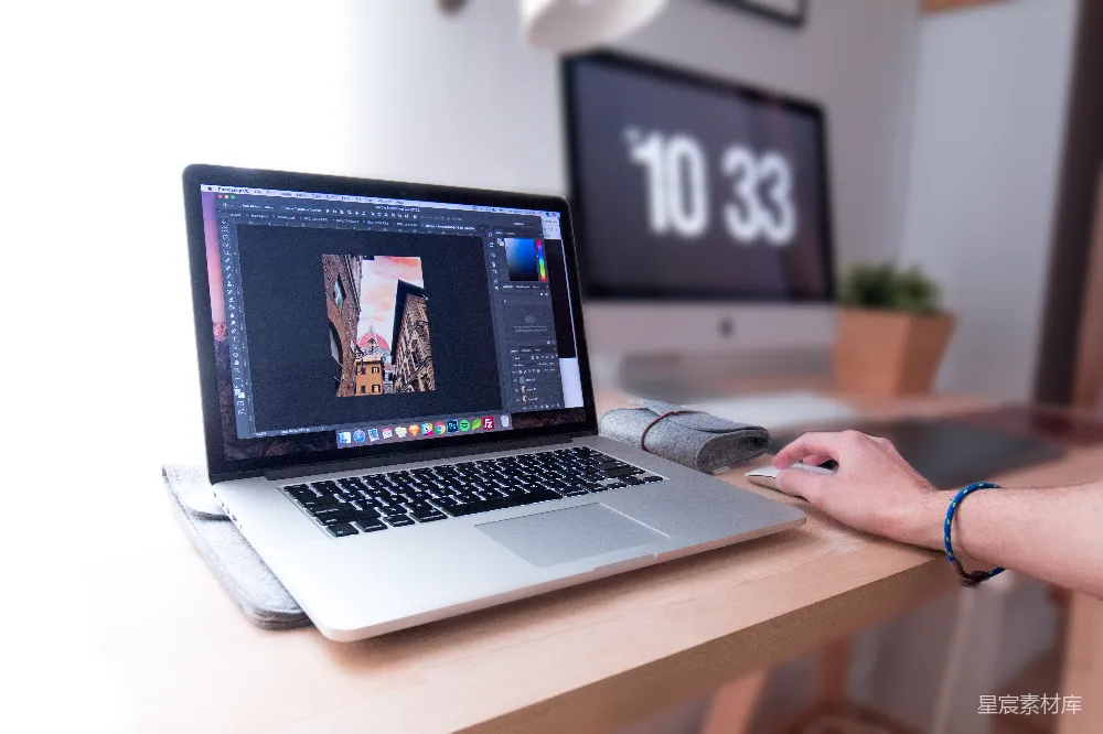 高清摄影  使用MacBook Pro的人在棕色木制书桌上。