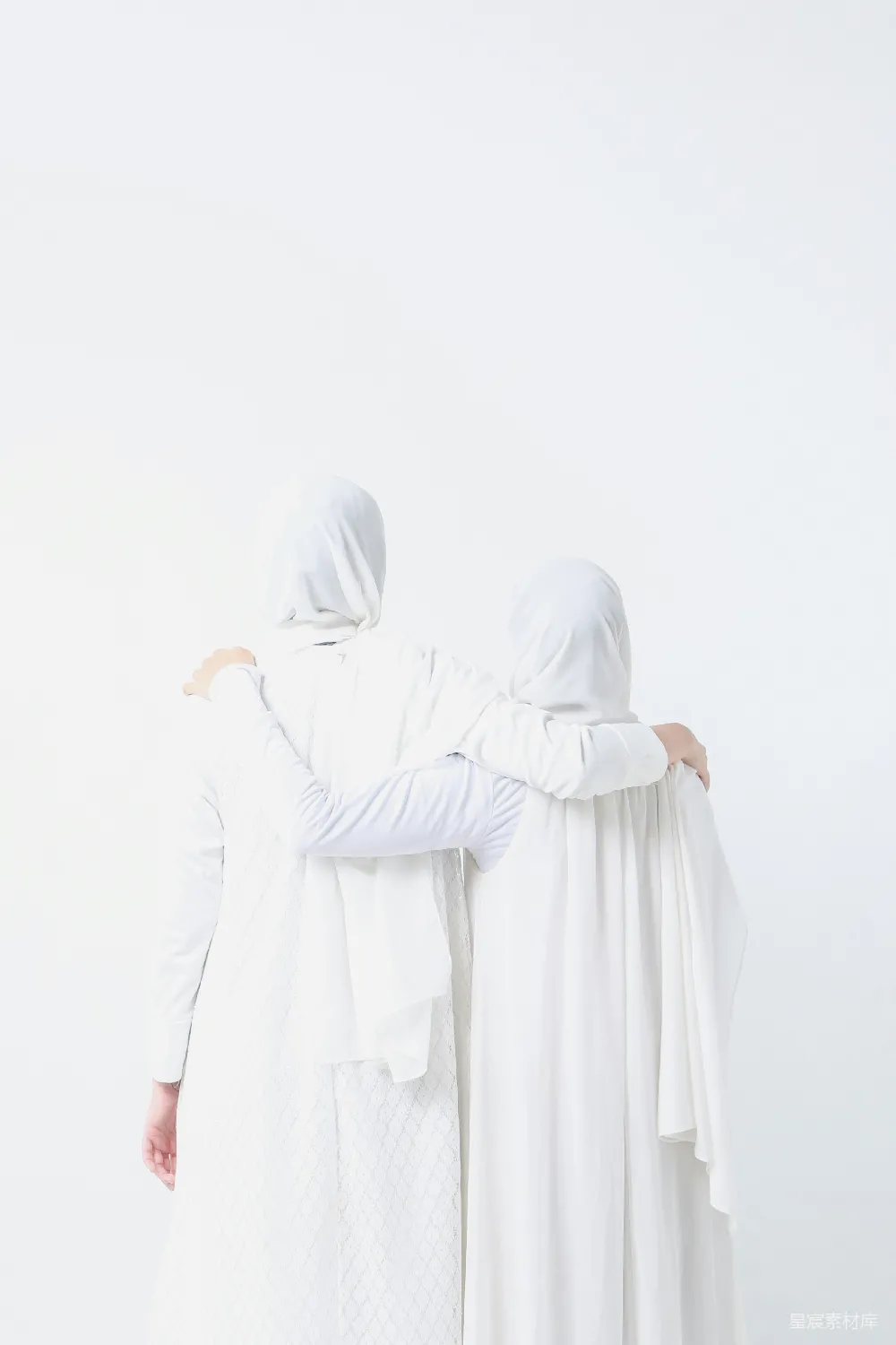 高清摄影  两个穿着白色衣服的女人并肩站着。