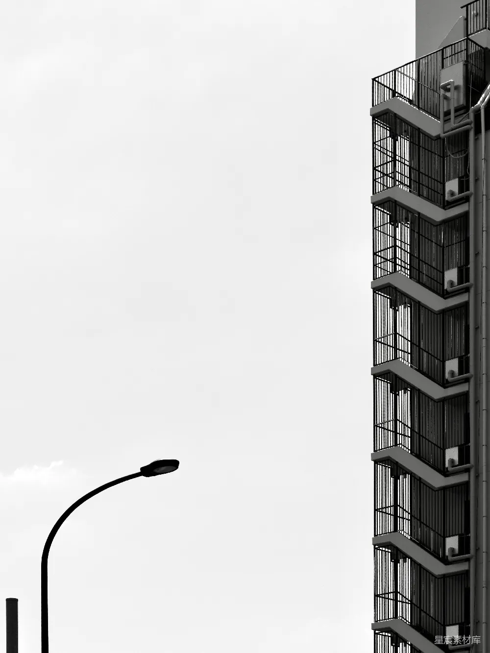 高清摄影  现代化建筑，配有外部消防逃生楼梯和路灯。