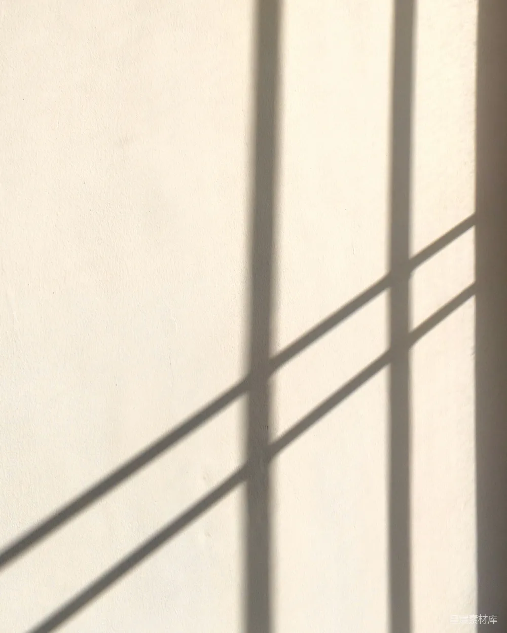 高清摄影  窗户的影子落在一堵米色的墙上。