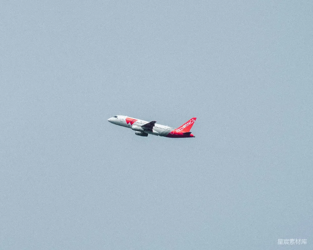 高清摄影  一架白色和红色的飞机在空中飞行。