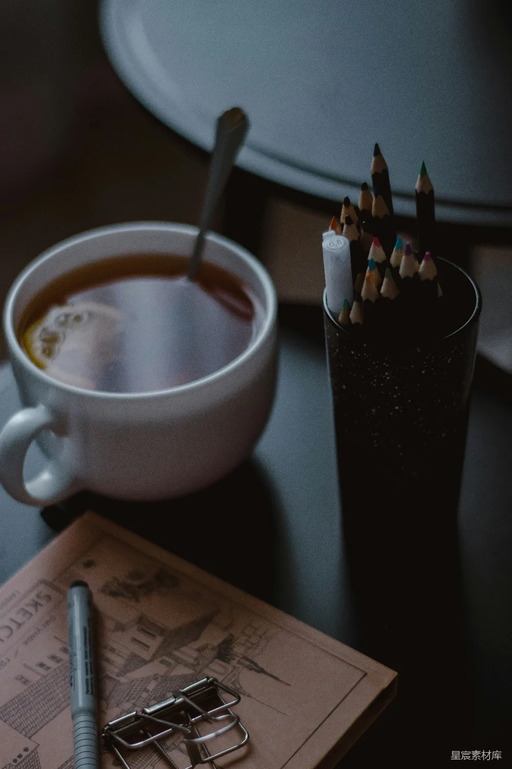 高清摄影  一张桌子上有咖啡杯和一个笔筒。