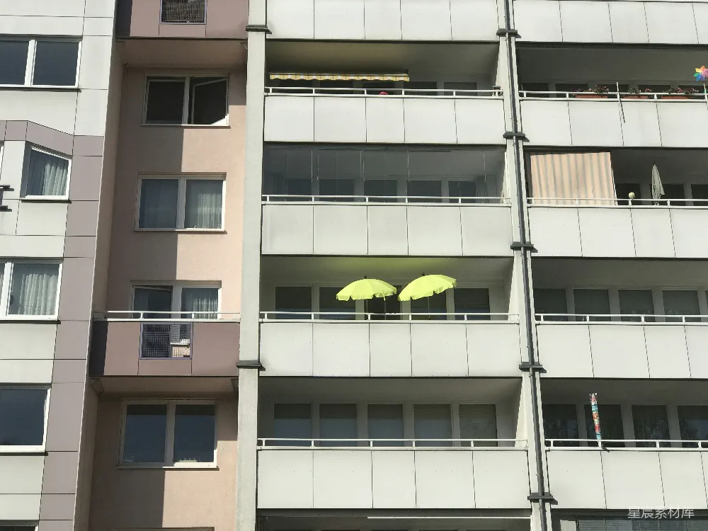 高清摄影  两把黄色雨伞摆放在公寓楼的阳台上。