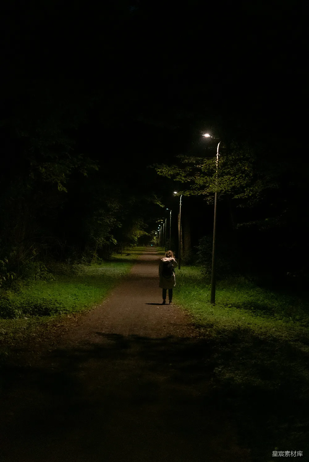 高清摄影  一个人在夜间沿着一条小路行走。