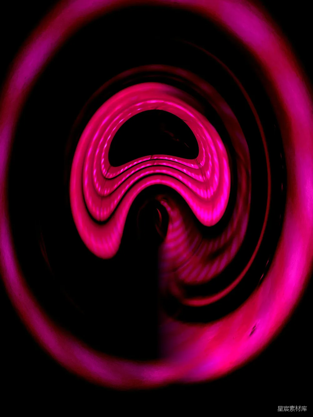 高清摄影  一个粉红色的漩涡在黑色背景的中间。