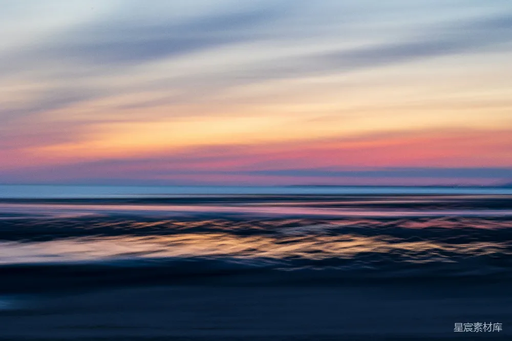 高清摄影 实验性 一张模糊的海景照片，夕阳在海平面上投下柔和的余晖。