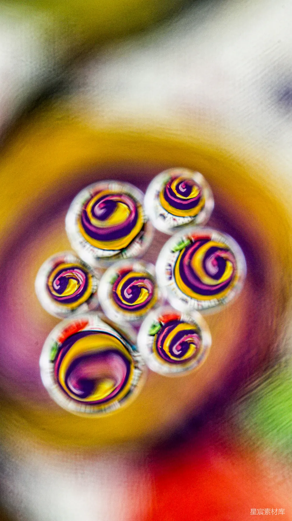 高清摄影  旋转着带有紫色和黄色中心的彩色水滴。