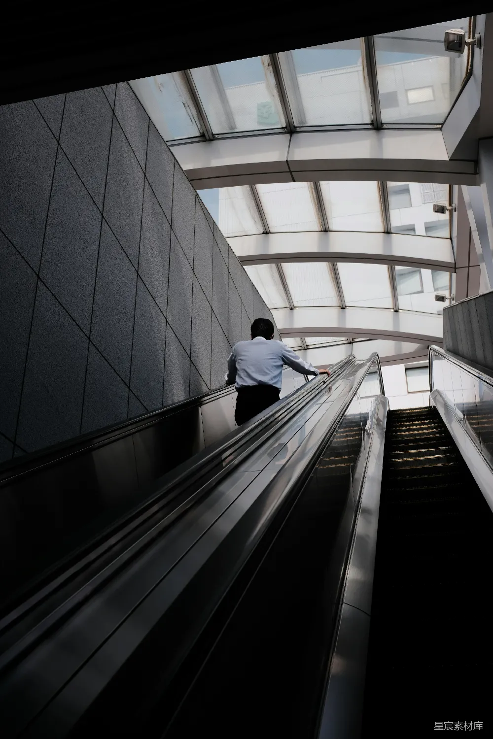 高清摄影  穿白色衬衫和黑色裤子的男人正走下楼梯。