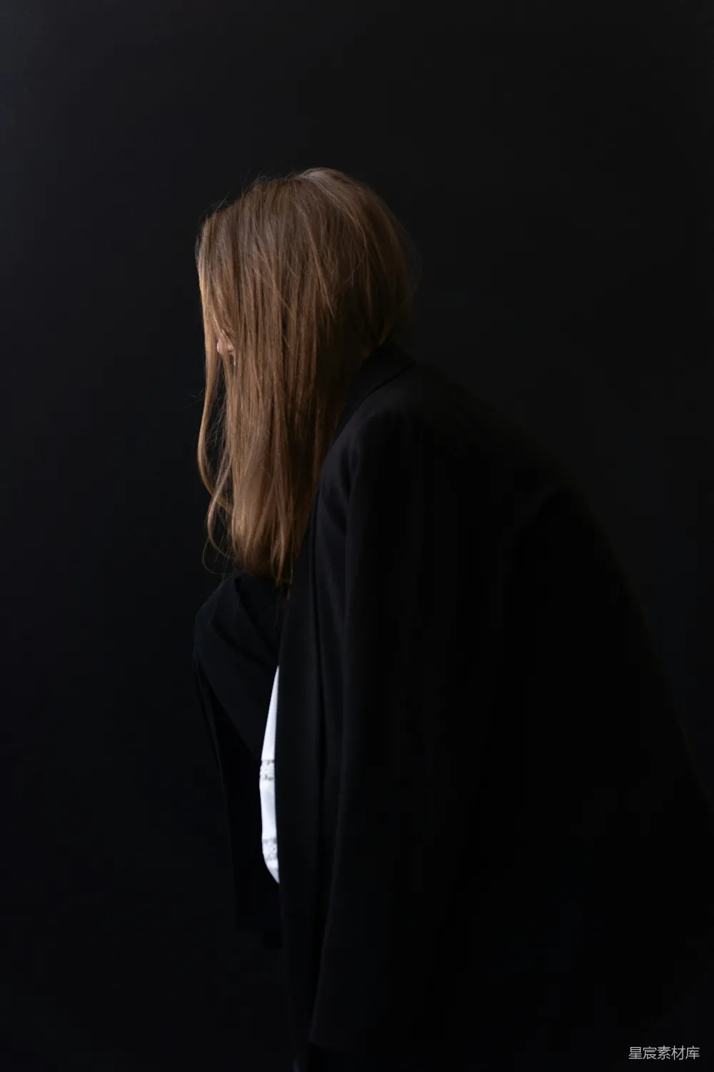 高清摄影  一个女人站在黑暗的房间里，背对着镜头。