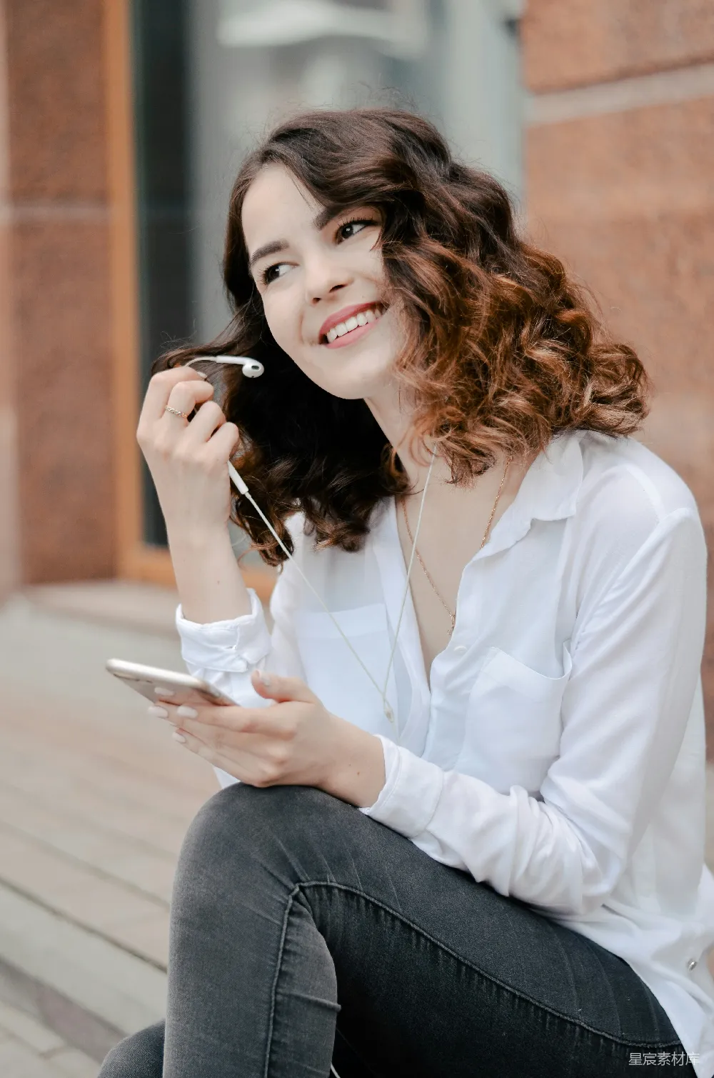 高清摄影  穿白色衬衫的女人拿着智能手机