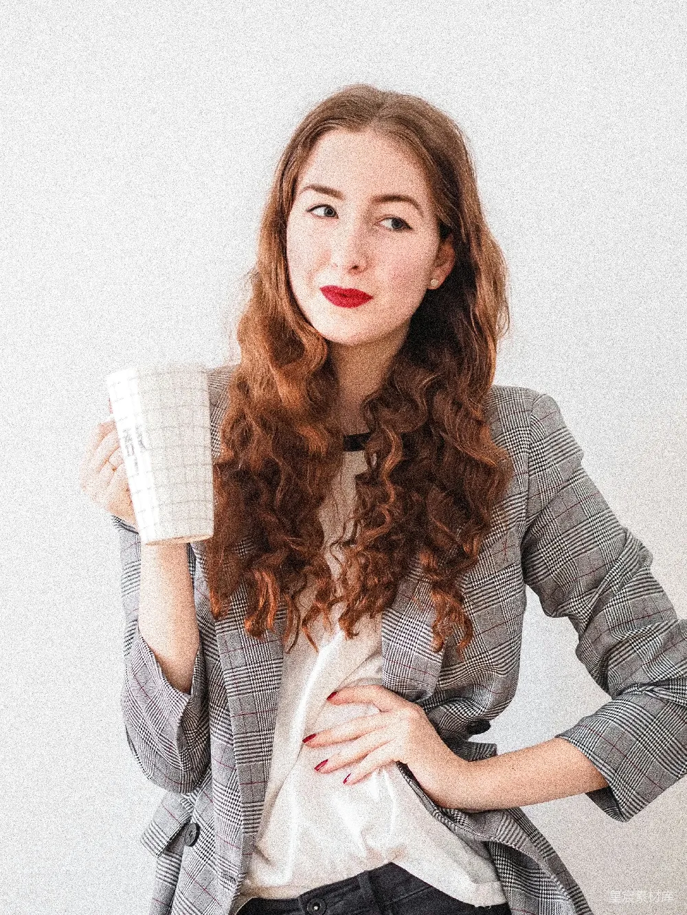 高清摄影  穿着灰色开衫的女人拿着一个白色的陶瓷杯子。