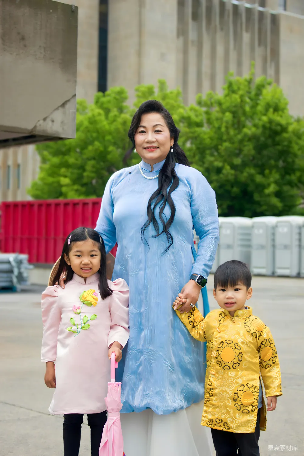 高清摄影  一个穿着传统越南服饰的女人和两个孩子在户外。