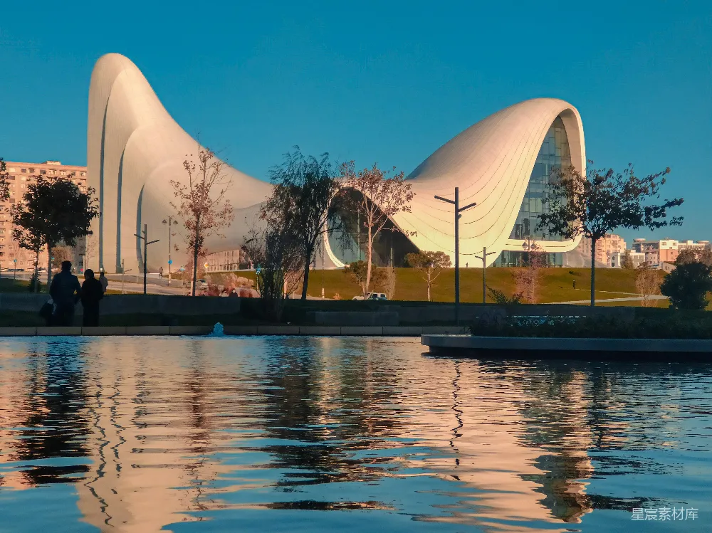高清摄影 现代建筑 城市景观 日落时分 水景 都市美学 波浪型建筑与倒影的宁静湖畔