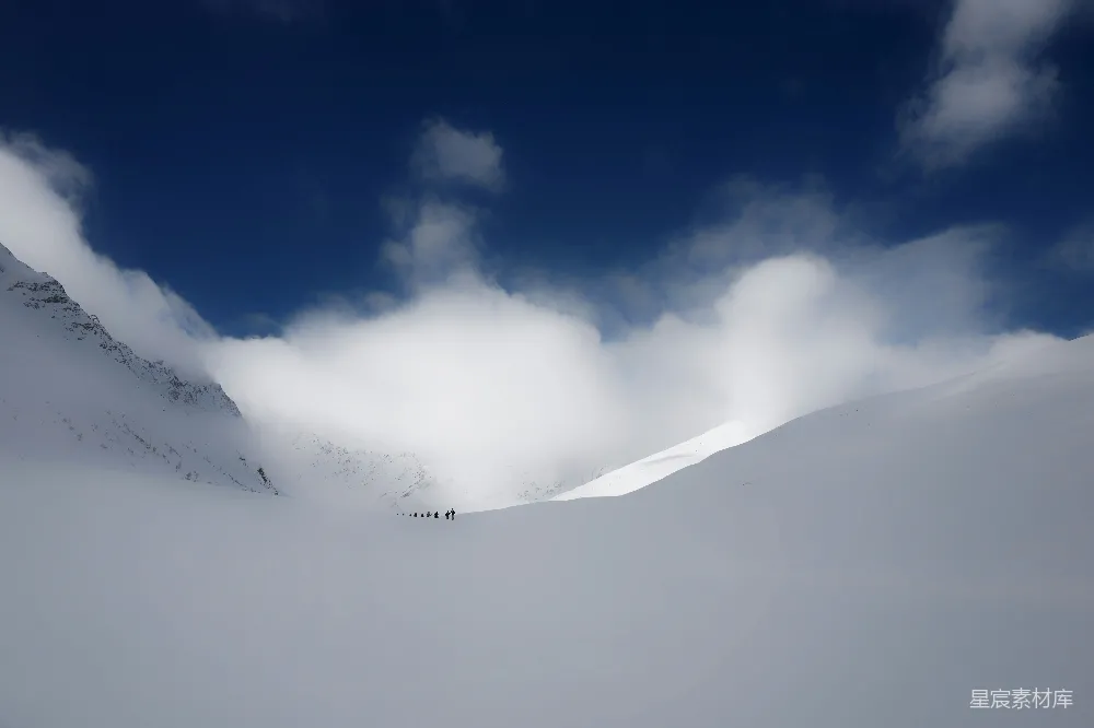 高清摄影  人在云层下的雪地里行走
