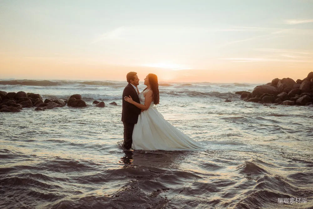 高清摄影 婚礼 情侣 夕阳 海滩 浪漫 夕阳下海中的婚礼夫妇