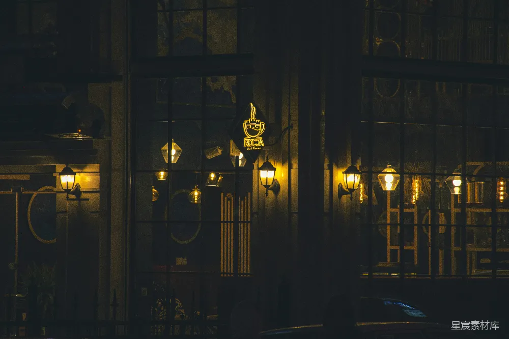 高清摄影  ```json {   title: 夜幕下的咖啡馆},   keys: [咖啡馆, 夜景, 复古, 灯光, 建筑],   descs: 夜幕降临，一盏盏温暖的灯光从咖啡馆的窗户中透出，营造出一种宁静