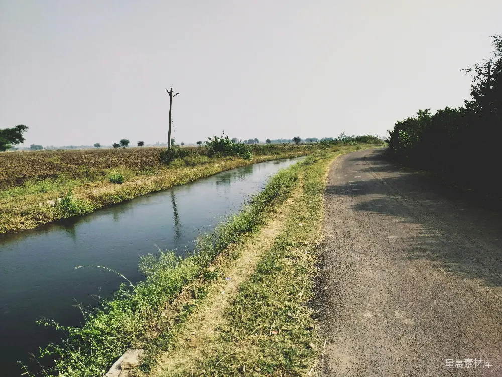 高清摄影 乡村 河流 小路 自然景观 宁静 乡村小路旁的河流