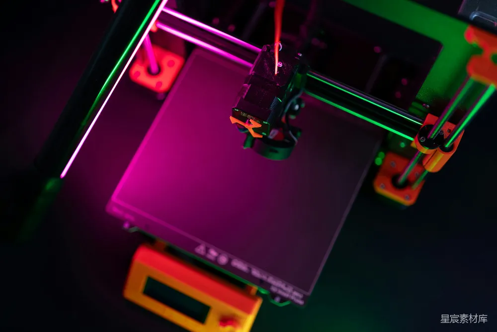 这是一张展示多彩3D打印机的图片，背景灯光为紫色和绿色，突出了设备的现代科技感。3D打印头在打印平台上移动，显示了3D打印过程的细节。这张图片适用于展示创新科技、3D打印技术和现代工业设计的主题。