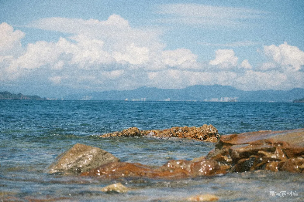 高清摄影 海滩 自然风光 城市景观 夏日度假 宁静 海边的岩石与远处的城市