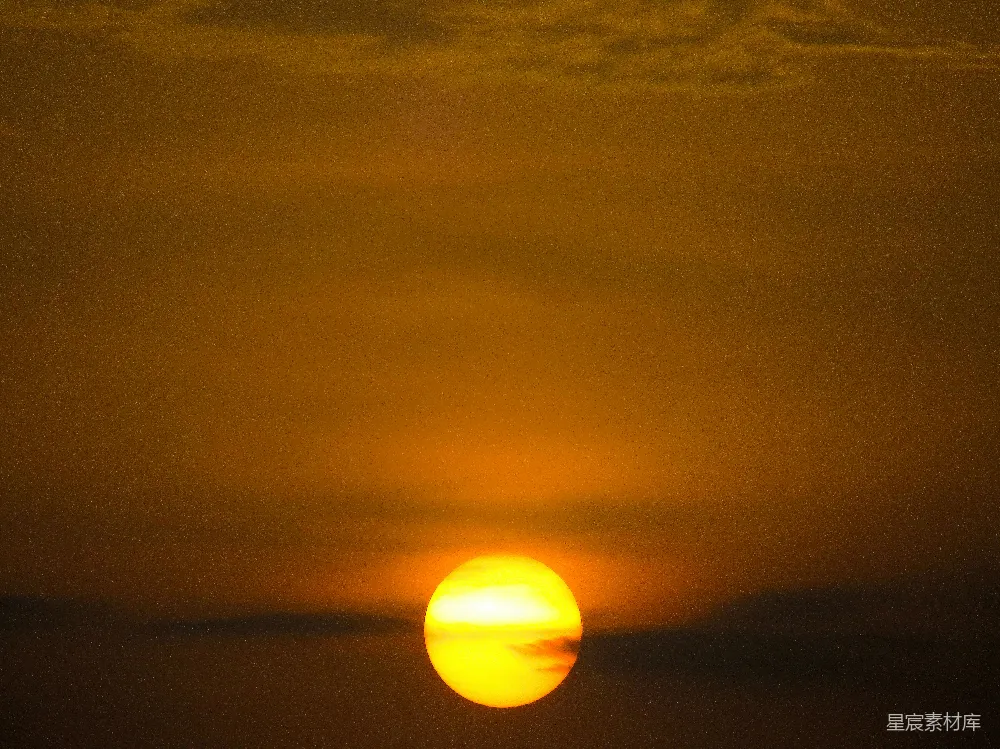 这张图片展示了一个宁静的黄昏时刻，夕阳的余晖洒在地平线上，天空被染成了温暖的橙色和黄色。这种场景通常用于表达宁静、和平和自然美的主题。