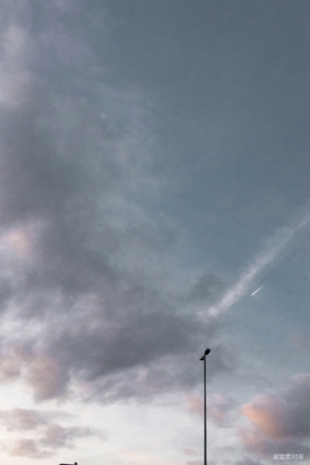 高清摄影 天空 阴云 街灯 飞机尾迹 城市 阴云密布下的街灯与飞机尾迹