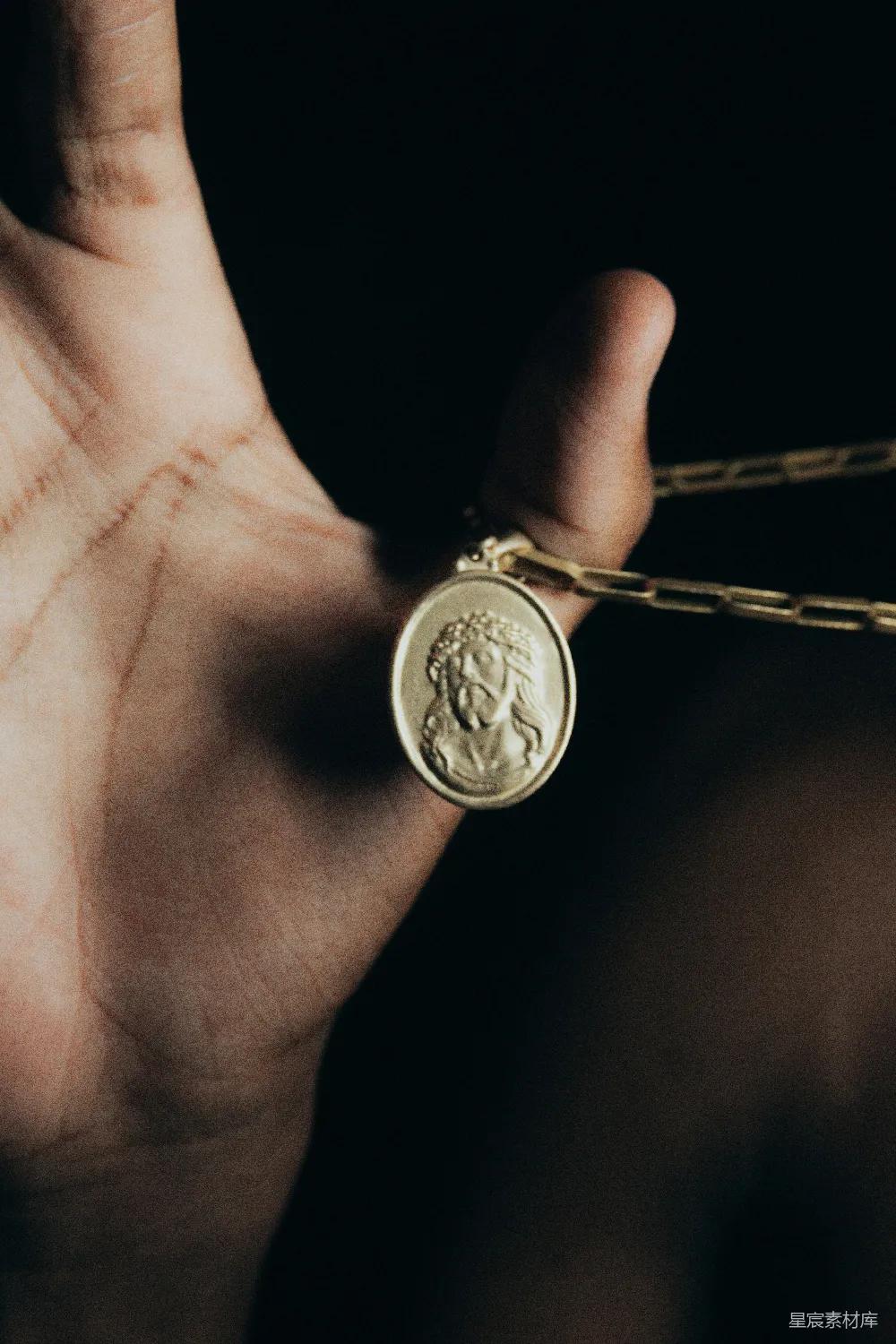 高清摄影 手部特写 金色吊坠 宗教符号 信仰象征 细节摄影 手中金色吊坠