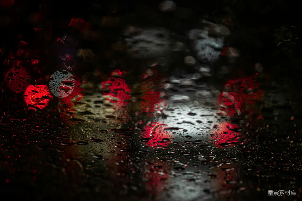 高清摄影  一幅雨淋窗户的特写镜头，红光闪烁。