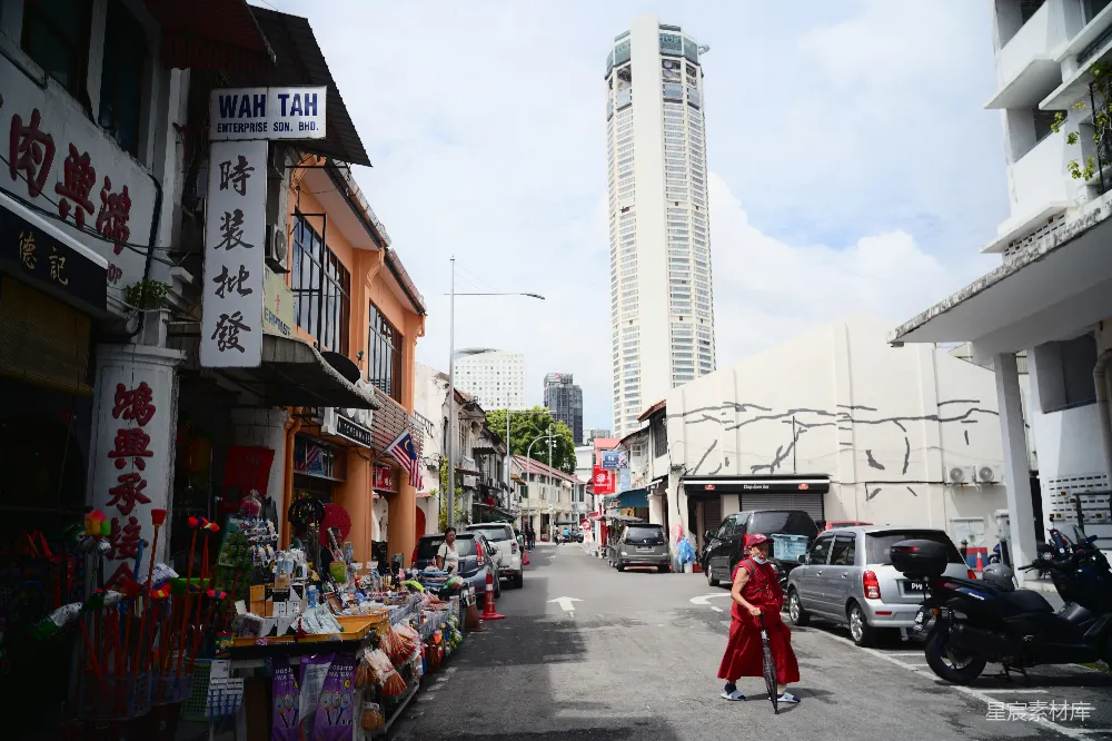 高清摄影  一个人走在有商店和高楼的街道上。