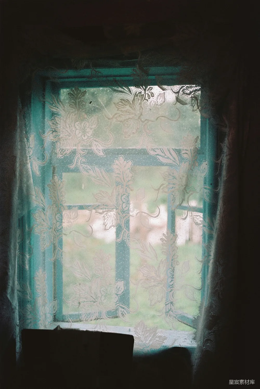 图片中，一扇带有精致花纹的窗纱被光线透射，呈现出柔和的朦胧效果。窗纱的花纹细腻，色彩柔和，给人一种宁静而神秘的感觉。适合用作背景或装饰元素，营造一种温暖而安静的氛围。