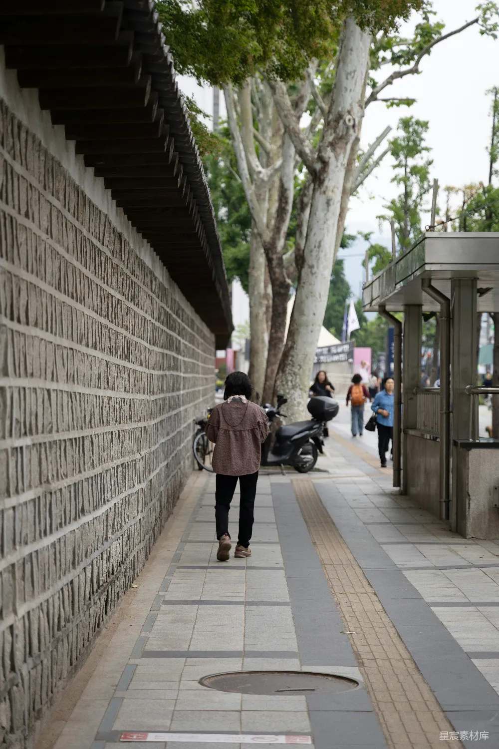 高清摄影 街道 石墙 行人 休闲 城市 石墙边的悠闲漫步