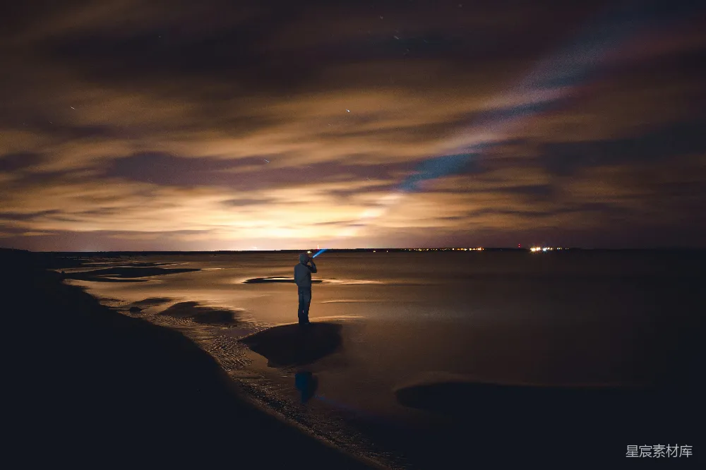 高清摄影 海滩 夜景 孤独 手电筒 宁静 海滩上的夜景：手电筒照亮的孤独身影