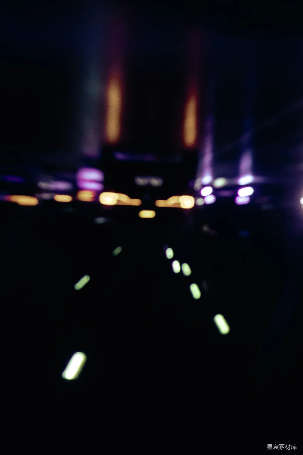 这张图片展示了夜景中的光斑效果，前景是模糊的光斑，背景则有些模糊的城市轮廓和灯光。整体色调偏暗，以黄色和紫色为主，营造出一种宁静而神秘的氛围，适合用于描述夜生活或城市夜景的主题。