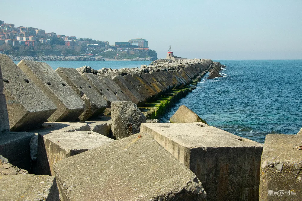 高清摄影 海岸线 混凝土结构 城市景观 自然与建筑结合 海岸防护 混凝土防波堤与远方的城市天际线