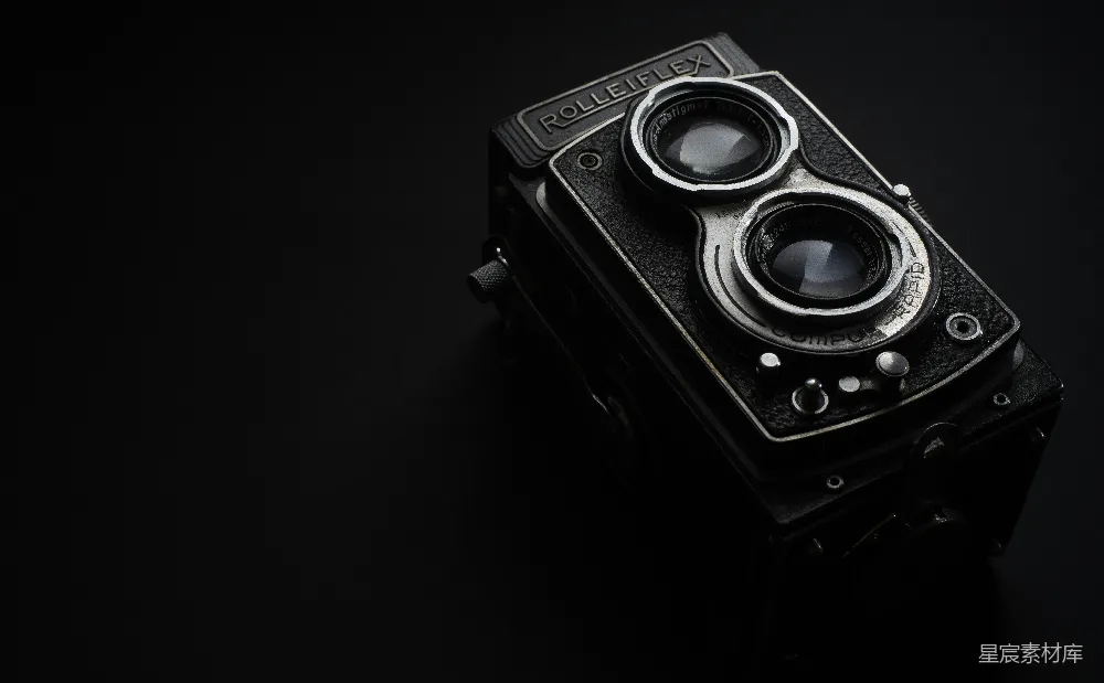 这是一张展示Rolleiflex双反相机的图片。相机置于黑色背景前，突显其独特的设计和精致的外观。Rolleiflex以其独特的双镜头结构和高清晰度而闻名，图片中相机的细节清晰可见，适合摄影爱好者或收藏家欣赏。