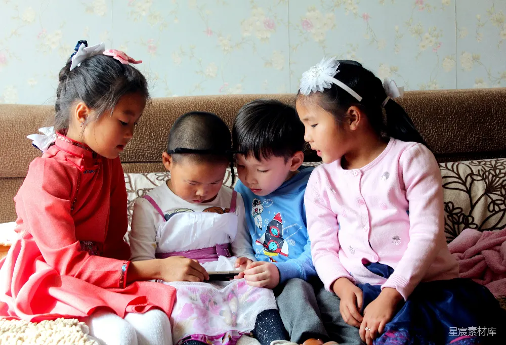 四兄妹坐在棕色沙发上，专注地看着手中的手机，表情各异。左边的女孩穿着红色裙子，戴着粉色头饰；中间两个男孩穿着休闲装，一个穿着白色衣服，另一个穿着蓝色衣服；右边的女孩穿着粉色外套，戴着白色头饰。背景是带有花卉图案的浅色墙纸。整个场景温馨而生动