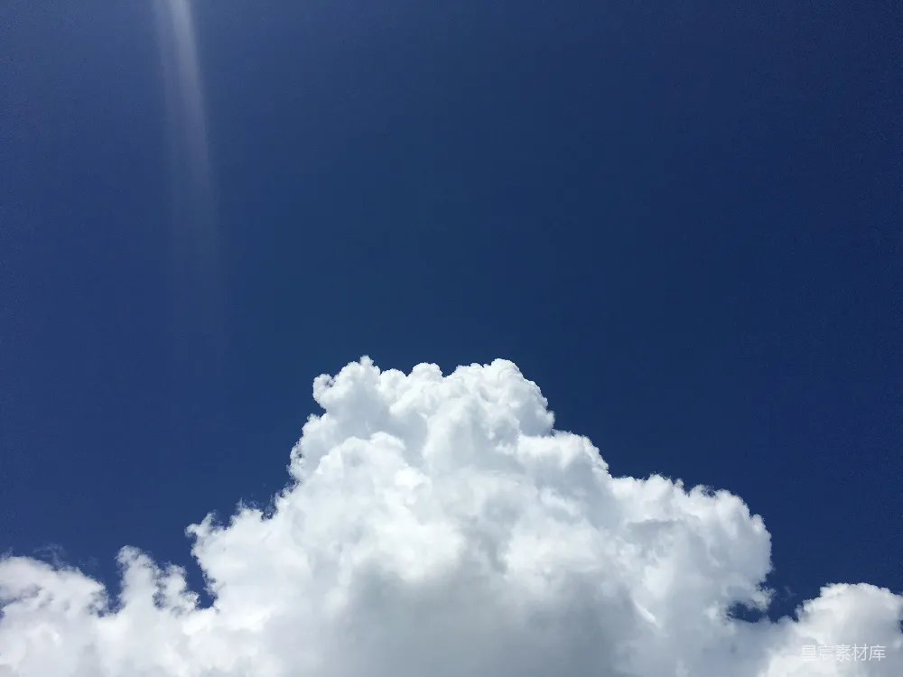 这张图片展示了蓝天下的大片白云，云朵蓬松洁白，天空湛蓝清澈，阳光从云层上方照射下来，给人一种宁静与开阔的感觉，适合用作自然风光或心情愉悦的背景图片。