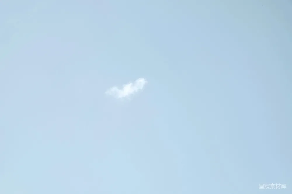 这是一张蓝天白云的照片，天空清澈，几朵白云在空中悠闲地飘动。这种景象给人一种宁静和平和的感觉，适合用作自然风光或放松心情的背景。