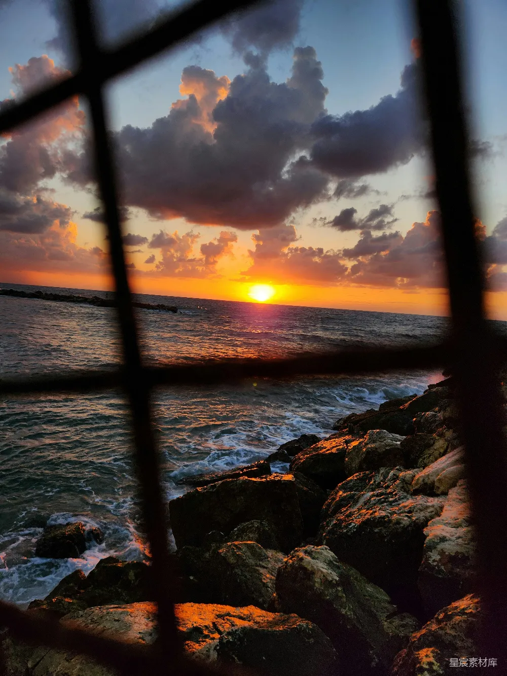 高清摄影 夕阳 铁窗 岩石 海浪 自然 夕阳透过铁窗映照岩石与海浪