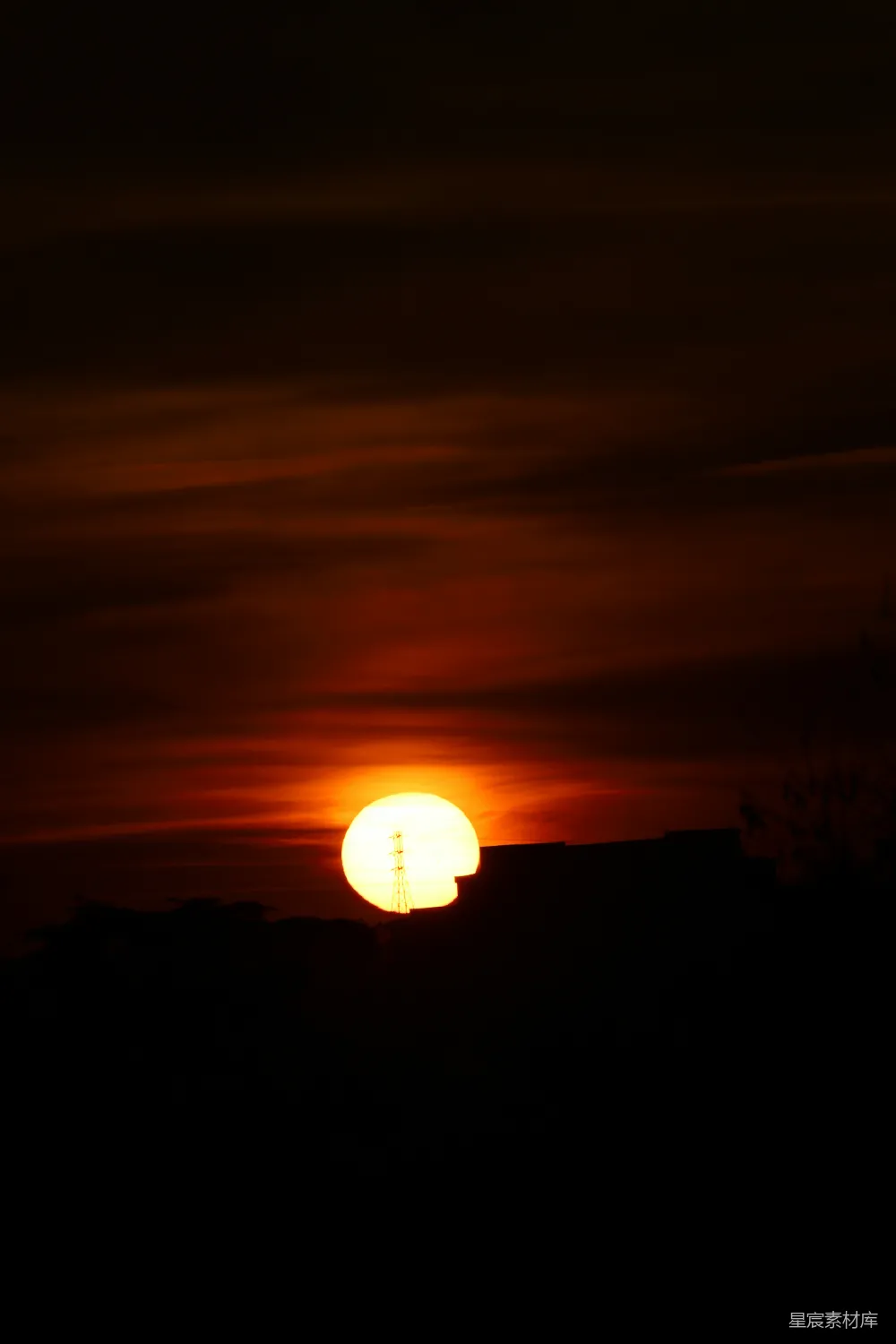 夕阳的余晖洒在城市上空，天空呈现出橙红色的渐变，建筑物和树木的轮廓在夕阳的余晖中显得格外清晰。这种场景既展现了自然的壮丽，也反映了城市生活的静谧与和谐。