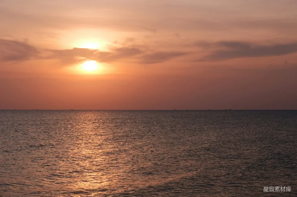 这张图片展示了日落时分的海景。夕阳的余晖洒在海面上，天空被染成了温暖的橙红色。海面波光粼粼，反射出夕阳的光辉，整个画面宁静而美丽，适合用于表现自然风景和放松心情的主题。